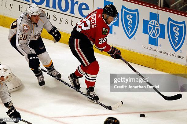 Kris Versteeg of the Chicago Blackhawks and Ryan Suter of the Nashville Predators chase down the puck in Game Five of the Western Conference...