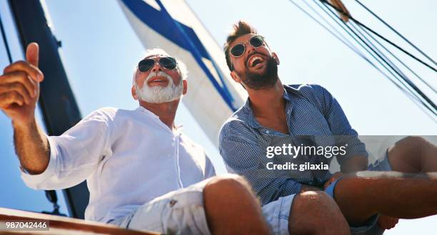 father and son sailing. - gilaxia stock pictures, royalty-free photos & images