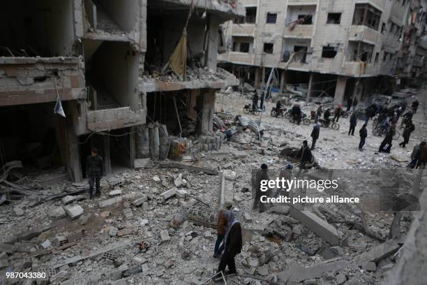 Syrians inspect the debris of buildings which destroyed by Syrian forces' missile strikes in Al Ghouta East, in Duma, Syria, 22 February 2018. More...