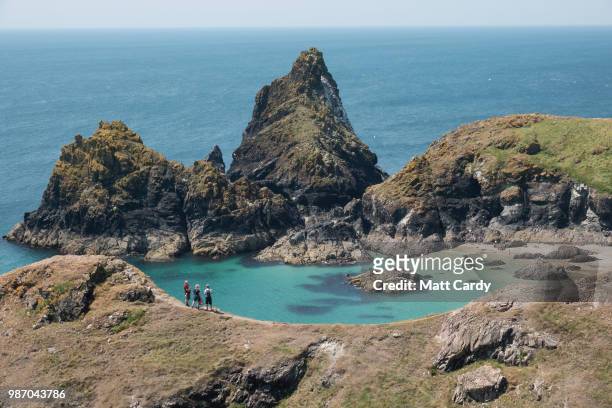 People enjoy the fine weather as they visit Kynance Cove on the Lizard Peninsula on June 29, 2018 in Cornwall, England. Parts of the UK are still...