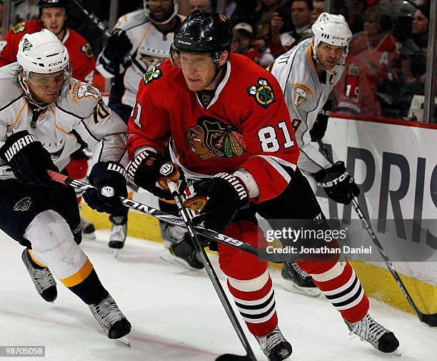 Marian Hossa of the Chicago Blackhawks chases down the puck under pressure from Martin Erat and Jason Arnott the Nashville Predators in Game Five of...