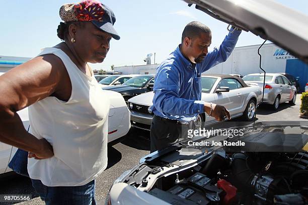 Ford salesman, Ted Warburton shows Darlene Washington the engine of the new Ford Escape she is purchasing from Metro Ford on April 27, 2010 in Miami,...