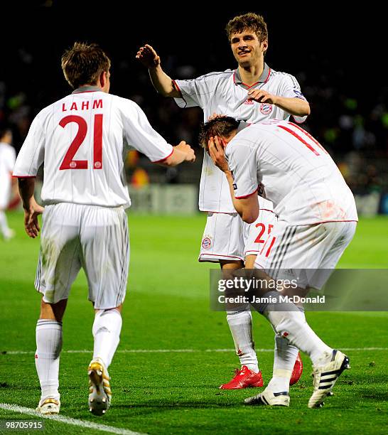 Bayern teammates Thomas Muller and Philipp Lahm celebrate as Ivica Olic of Bayern Muenchen holds the cut on his head gained whilst scoring his team's...