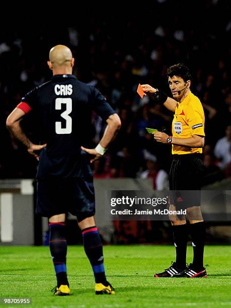 Cris of Olympique Lyonnais is shown the red card by Referee Massimo Busacca of Switzerland after his tackle on Ivica Olic of Bayern Muenchen during...