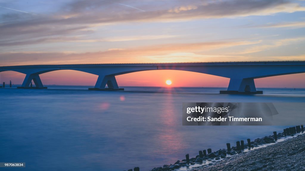 Zeeland Bridge during sunset in the Netherlands.
