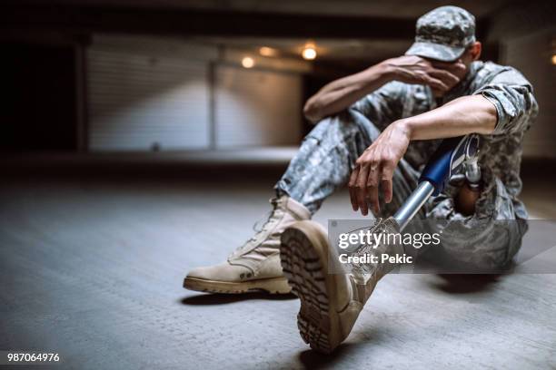 young amputee soldier crying in bunker - amputee rehab stock pictures, royalty-free photos & images