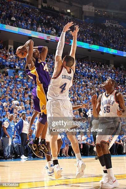 Kobe Bryant of the Los Angeles Lakers jumps up to pass over Nick Collison and Kevin Durant of the Oklahoma City Thunder in Game Three of the Western...