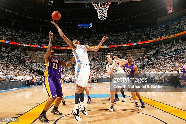 Thabo Sefolosha of the Oklahoma City Thunder reaches for a rebound over Josh Powell of the Los Angeles Lakers in Game Four of the Western Conference...