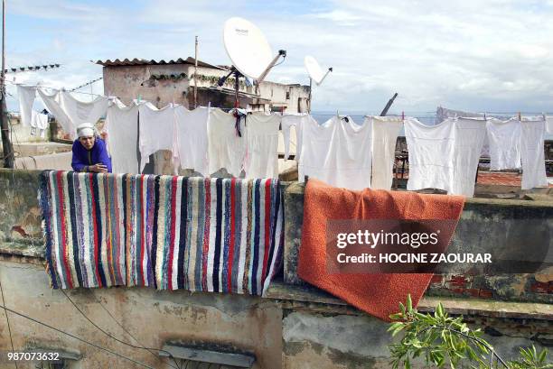 Vue aérienne prise le 14 février 2003 d'une Algérienne sur la terrasse de sa maison avec des antennes satellitaires et le linge qui sèche dans la...