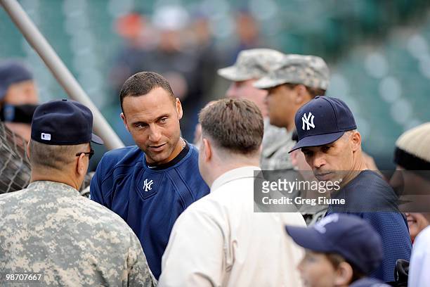 Derek Jeter and Manager Joe Girardi of the New York Yankees talk with members of the United States Military before the game against the Baltimore...