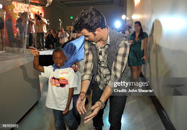 Musician Kevin Jonas of the Jonas Brothers gives students from Manhattan Place Elementary School a tour at the Natural History Museum on April 27,...