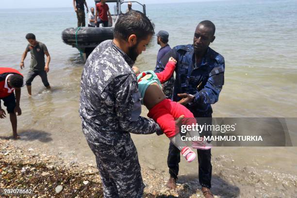 Graphic content / Members of the Libyan security forces carry the body of a baby as migrants who survived the sinking of an inflatable dinghy boat...