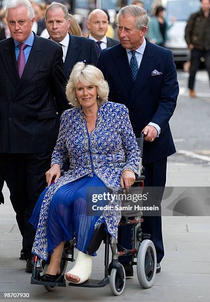 Prince Charles, Prince of Wales pushes Camilla, Duchess of Cornwall in a wheel chair as they arrive for the Premiere of 'Aida' at the Royal Opera...