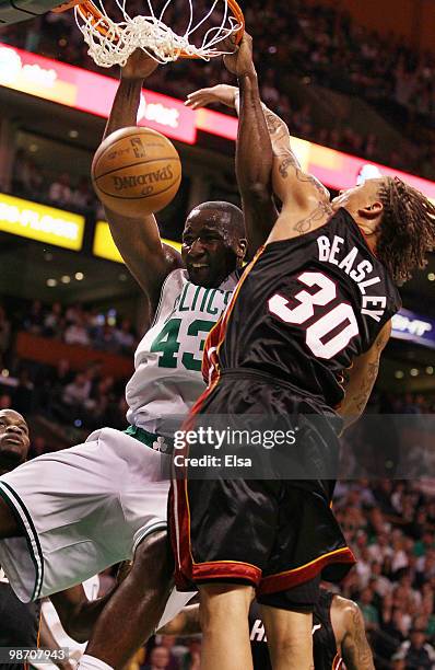 Kendrick Perkins of the Boston Celtics dunks the ball as Michael Beasley of the Miami Heat defends during Game Five of the Eastern Conference...