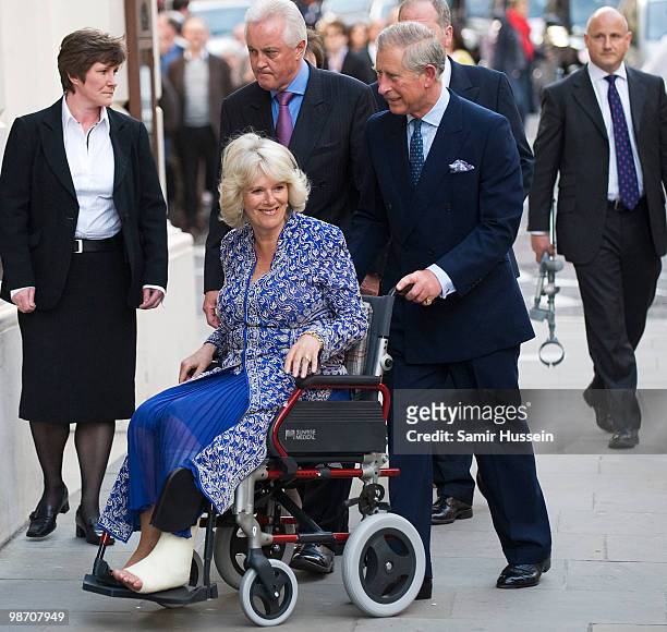 Prince Charles, Prince of Wales pushes Camilla, Duchess of Cornwall in a wheel chair as they arrive for the Premiere of 'Aida' at the Royal Opera...