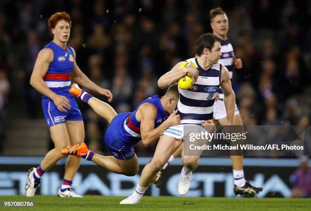 Patrick Dangerfield of the Cats is tackled during the 2018 AFL round15 match between the Western Bulldogs and the Geelong Cats at Etihad Stadium on...