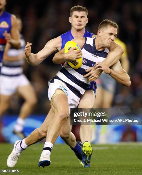 Joel Selwood of the Cats is tackled by Billy Gowers of the Bulldogs during the 2018 AFL round15 match between the Western Bulldogs and the Geelong...