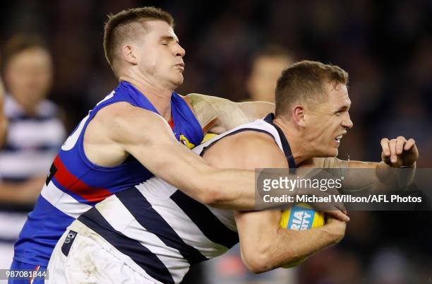 Joel Selwood of the Cats is tackled by Billy Gowers of the Bulldogs during the 2018 AFL round15 match between the Western Bulldogs and the Geelong...