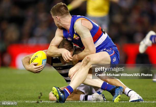 Joel Selwood of the Cats is tackled by Billy Gowers of the Bulldogs during the 2018 AFL round15 match between the Western Bulldogs and the Geelong...