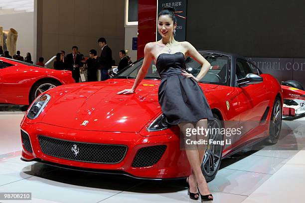 Model stands beside a Ferrari 599 GTO during the Beijing Auto Show on April 27, 2010 in Beijing of China. Major global automakers plan to unveil...