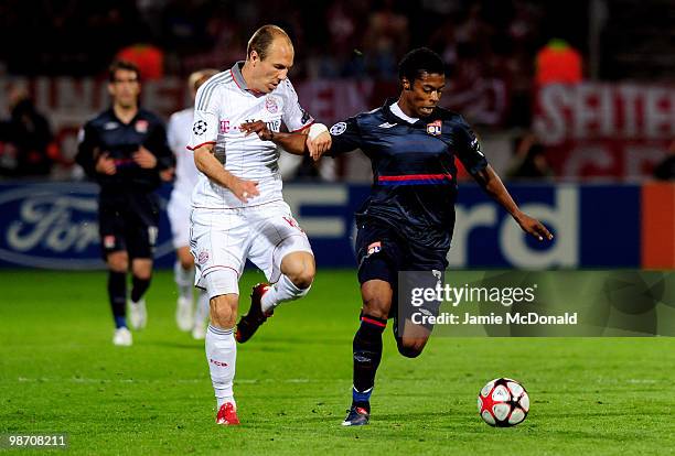 Michel Bastos of Olympique Lyonnais holds off the challenge from Arjen Robben of Bayern Muenchen during the UEFA Champions League semi final second...