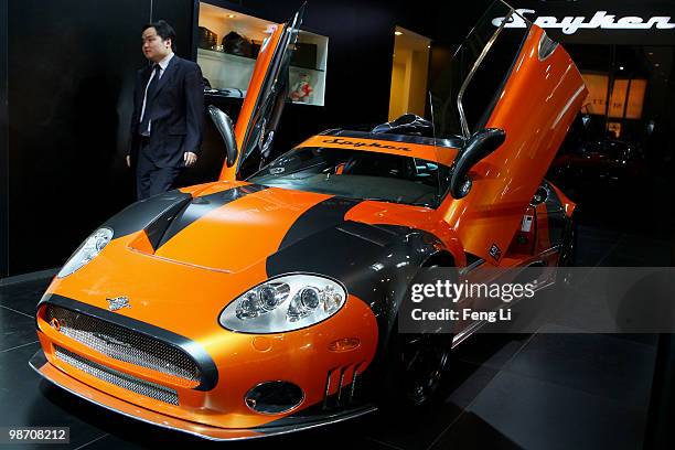 Salesman passes by a Spyker C8 Laviolette LM85 during the Beijing Auto Show on April 27, 2010 in Beijing of China. Major global automakers plan to...