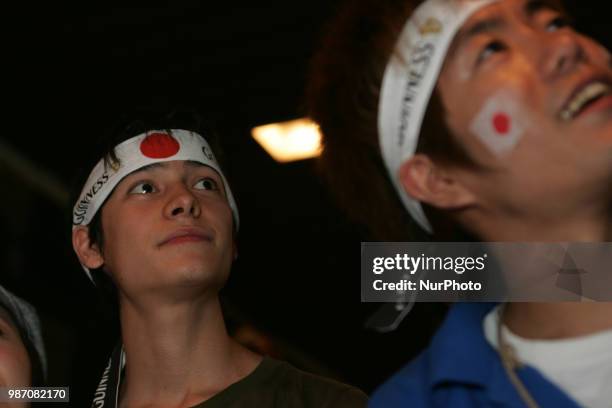 Japanese fans react as they watch a broadcast of the World Cup Group H soccer match Japan vs Poland, at a sports bar in Tokyo, Japan, June 29, 2018.
