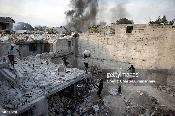Men and Women loot a destroyed store after the tragic earthquake that has killed thousands on January 19, 2010 in Port Au Prince, Haiti. Looting has...