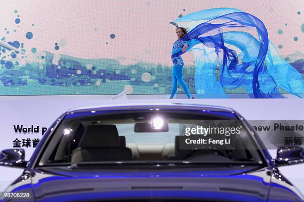 Dancer performs beside the world premiere display of Volkswagen new Phaeton during the Beijing Auto Show on April 27, 2010 in Beijing of China. Major...
