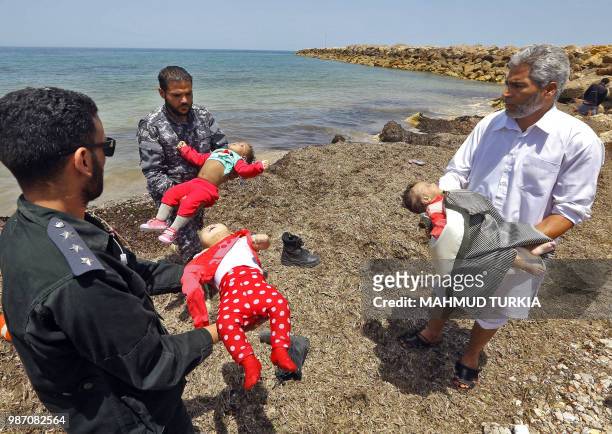 Graphic content / Members of the Libyan security forces and a civilian carry the bodies of babies as migrants who survived the sinking of an...