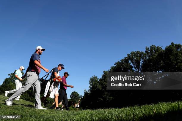 Bill Haas, Marc Leishman of Australia and Tiger Woods walk to the 12th fairway during the second round of the Quicken Loans National at TPC Potomac...
