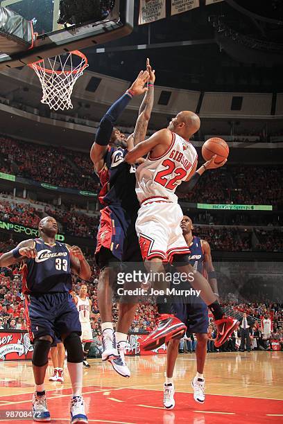 Taj Gibson of the Chicago Bulls puts a shot up against LeBron James of the Cleveland Cavaliers during Game Three of the Eastern Conference...