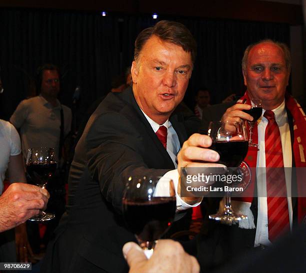 Head coach Louis van Gaal of Muenchen drinks a glass of red vine next to president Uli Hoeness at the Champions League dinner after reaching the...