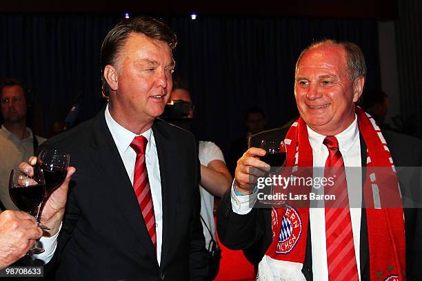 Head coach Louis van Gaal of Muenchen drinks a glass of red vine next to president Uli Hoeness at the Champions League dinner after reaching the...