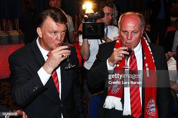 Head coach Louis van Gaal of Muenchen drinks a glass of red vine next to president Uli Hoeness at the Champions League dinner after reaching the...