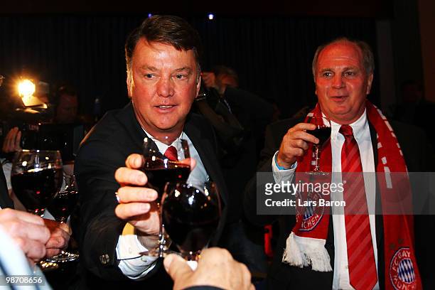 Head coach Louis van Gaal of Muenchen drinks a glass of red vine next to president Uli Hoeness at the Champions League dinner after reaching the...