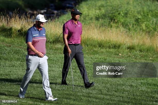 Marc Leishman of Australia and Tiger Woods walk up the 10th hole during the second round of the Quicken Loans National at TPC Potomac on June 29,...