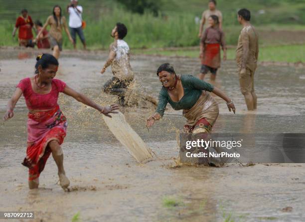 Nepalese farmers throw mud water to each other at paddy field during National Paddy Day or Asar Pandra, which marks the commencement of rice crop...