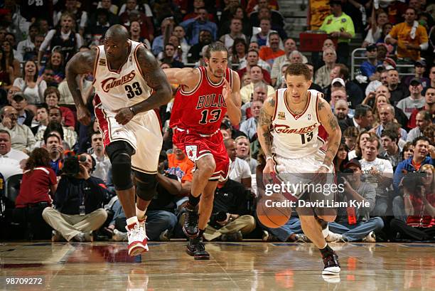 Delonte West of the Cleveland Cavaliers brings the ball down the court trailed by teammate Shaquille O'Neal and Joakim Noah of the Chicago Bulls in...