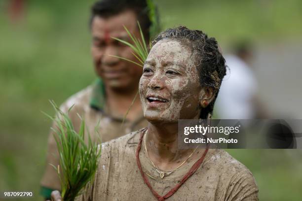 Nepalese woman covered in mud smiles as she dance at paddy field during National Paddy Day or Asar Pandra, which marks the commencement of rice crop...
