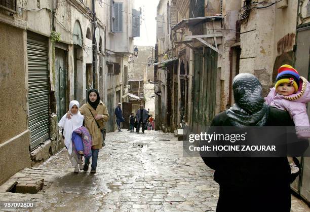 Des Algérois, enfants et adultes, passent le 14 février 2003 dans une rue de la Casbah d'Alger. La remise en état des maisons de la Casbah, dans un...