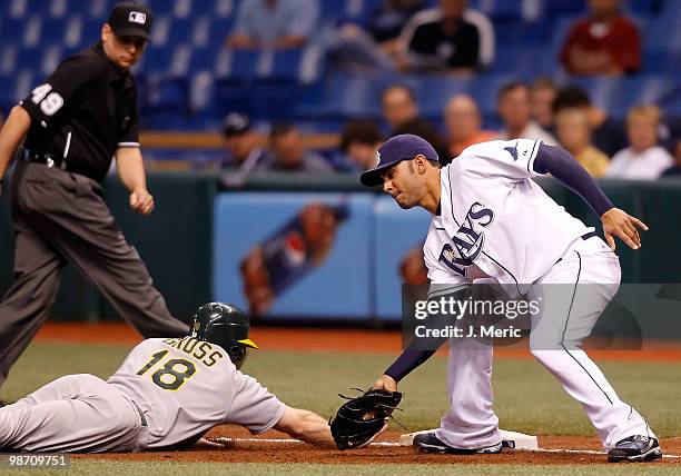 Infielder Carlos Pena of the Tampa Bay Rays applies the tag to Gabe Gross of the Oakland Athletics as Gross gets back safely to first during the game...