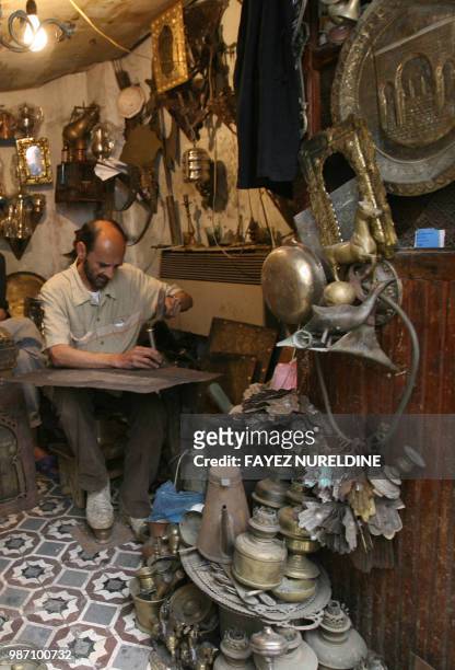 An Algerian man works at his traditional shop in the historical Casbah distrisct in Algiers City 25 May 2006. Once a sparkling white medina, or...