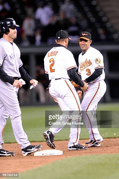 Cesar Izturis of the Baltimore Orioles celebrates with Julio Lugo after the final out against the New York Yankees at Camden Yards on April 27, 2010...