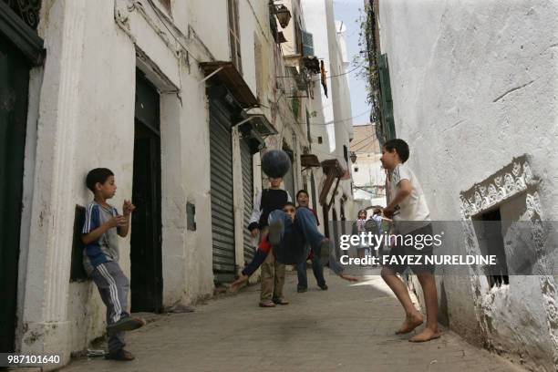 Algerian boys play football in a street of the historical casbah distrisct in Algiers City 17 May 2006. Once a sparkling white medina, or Islamic...