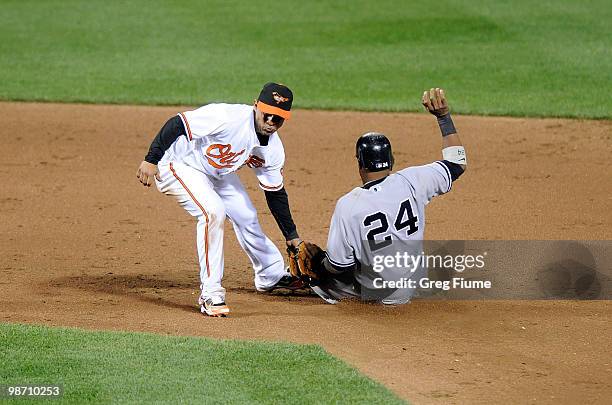 Robinson Cano of the New York Yankees is caught trying to steal second base by Cesar Izturis of the Baltimore Orioles at Camden Yards on April 27,...