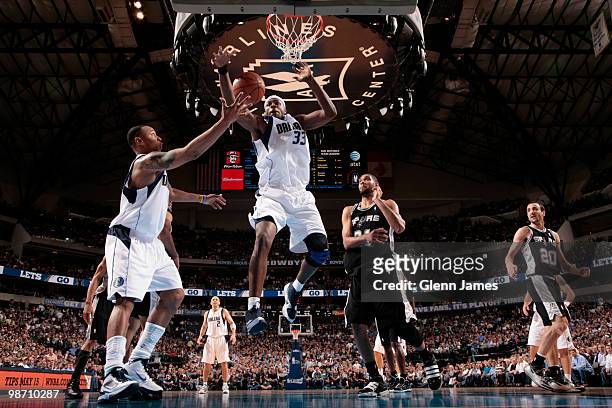 Caron Butler and Brendan Haywood of the Dallas Mavericks try to corral the rebound against Tim Duncan of the San Antonio Spurs in Game Five of the...