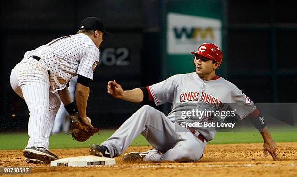 Joey Votto of the Cincinnati Reds slides safely into third base as third baseman Geoff Blum is late on the tag in the ninth inning at Minute Maid...