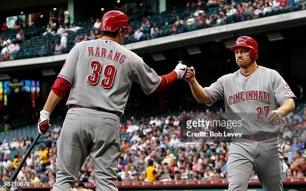 Scott Rolen of the Cincinnati Reds is welcomed at home plate by pitcher Aaron Harang after scoring in the second inning against the Houston Astros at...