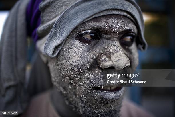 Man covered with debris stands in a neighborhood of Canape Vert on January 16, 2010 in Port-au-Prince, Haiti.